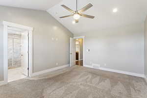 Empty room featuring light colored carpet, high vaulted ceiling, and ceiling fan