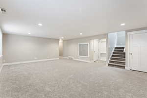 Basement featuring light colored carpet