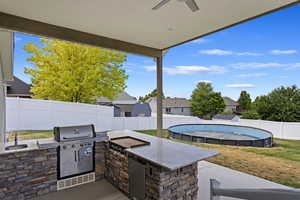 View of patio / terrace with sink, exterior kitchen, and a fenced in pool