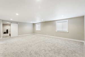 Basement with a barn door and carpet