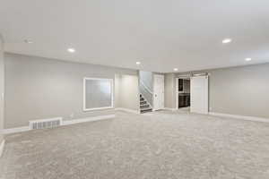 Basement with light carpet and a barn door