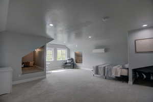 Bonus room with vaulted ceiling, carpet, a textured ceiling, a wall mounted air conditioner, kids sleeping nooks