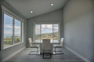 Dining space featuring vaulted ceiling and hardwood / wood-style floors