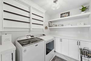 Laundry room featuring drying rack, cabinets, and light tile flooring