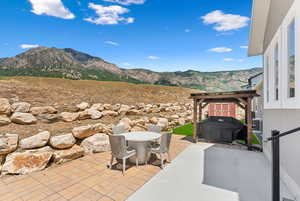 View of patio with a mountain view and a grill