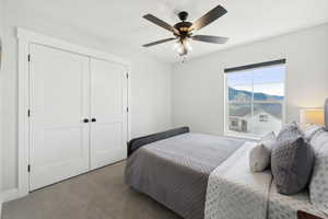 Carpeted bedroom with a closet and ceiling fan