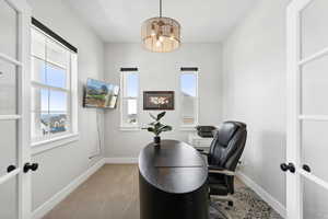 Carpeted office with french doors and a wealth of natural light