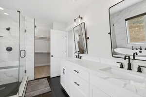 Bathroom with tile flooring, independent shower and bath, and double sink vanity