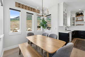 Dining room featuring sink, a chandelier, and light wood-type flooring