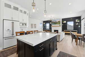 Kitchen featuring white cabinetry, a wealth of natural light, built in appliances, and light wood-type flooring