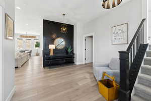 Living room featuring wood-type flooring and an inviting chandelier