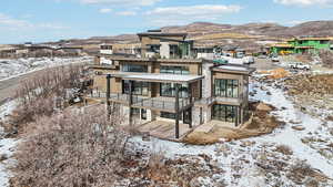 Snow covered rear of property featuring a mountain view