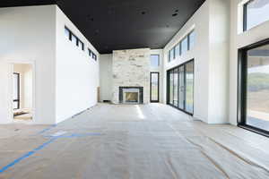 Unfurnished living room with a fireplace and a high ceiling