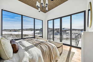 Bedroom featuring a chandelier, light wood-type flooring, vaulted ceiling, and wooden ceiling