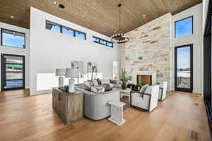 Living room with a chandelier, a towering ceiling, and light hardwood / wood-style flooring