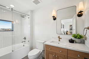 Full bathroom featuring toilet, combined bath / shower with glass door, and vanity