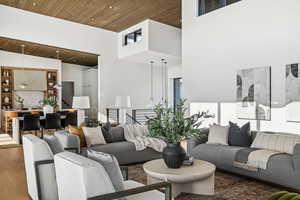 Living room featuring a towering ceiling, hardwood / wood-style flooring, and wood ceiling