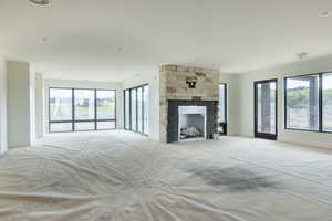 Unfurnished living room with a stone fireplace