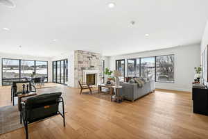 Living room with light hardwood / wood-style flooring and a stone fireplace