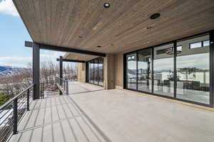 Snow covered deck with a water and mountain view