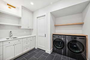 Laundry room featuring separate washer and dryer and sink