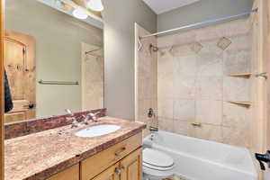 Full bathroom featuring large vanity, toilet, and tiled shower / bath combo