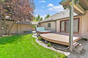 View of yard with a hot tub, french doors, and a deck