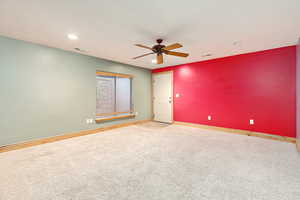 Basement entry room with ceiling fan and carpet floors