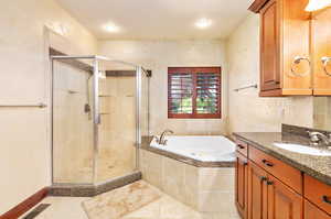 Primary bathroom featuring tile floors, oversized vanity, and separate shower and tub