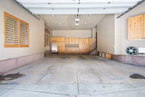 Heated garage featuring a garage door opener and stainless steel fridge