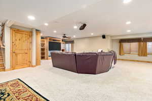 Carpeted living room with ceiling fan