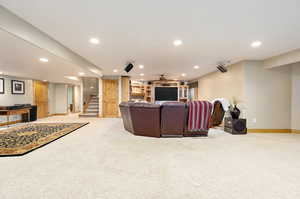 Carpeted living room featuring ceiling fan