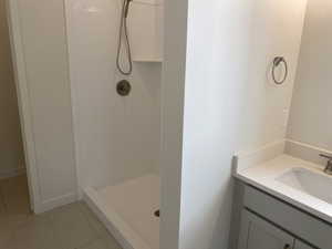 Jr. Owners Retreat on-suite bathroom with vanity, walk in shower, and tiled floors