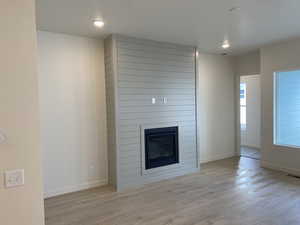 Lving room with light hardwood / wood-style flooring and a large fireplace