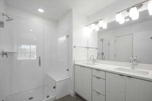 Bathroom with an enclosed shower, double sink, and oversized vanity