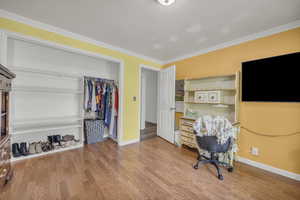 Office area featuring wood-type flooring and ornamental molding