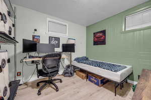 Office area with a textured ceiling and wood-type flooring