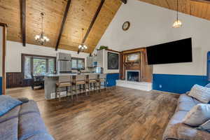 Living room with high vaulted ceiling, beam ceiling, wooden ceiling, and wood-type flooring