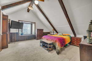 Bedroom with ceiling fan, vaulted ceiling, and light carpet