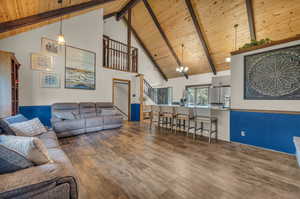 Living room featuring high vaulted ceiling, wood-type flooring, beamed ceiling, and wood ceiling