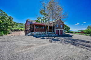 Log home with a garage and a porch