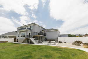 Back of house with a yard and a patio