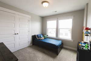 Carpeted bedroom with a closet