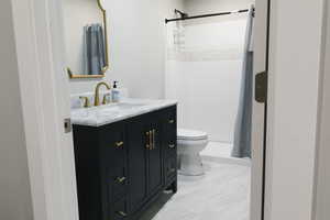 Bathroom with tile floors, walk in shower, toilet, and vanity