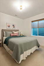 Bedroom featuring a textured ceiling and carpet