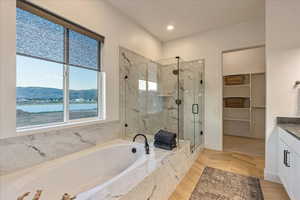 Bathroom featuring a water and mountain view, plus walk in shower, and vanity