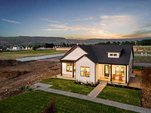 Modern farmhouse style home featuring a lawn and a mountain view