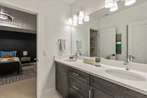 Bathroom with oversized vanity, dual sinks, and tile floors