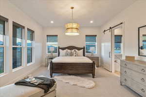 Bedroom with light carpet and a barn door