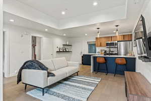 Main floor condo featuring open concept living room, kitchen, bar, office space with vaulted ceiling.